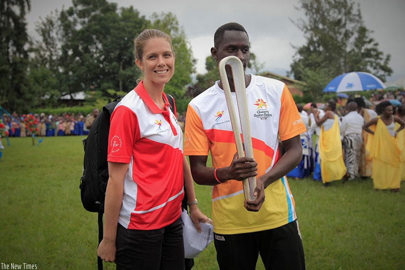 National swimmer Bebeto Isahaka Irankunda holds the baton as Trish Quayle, the Queens Baton Relay Communication manager, looks on in Rubavu District on Wednesday. Sam Ngendahimana.