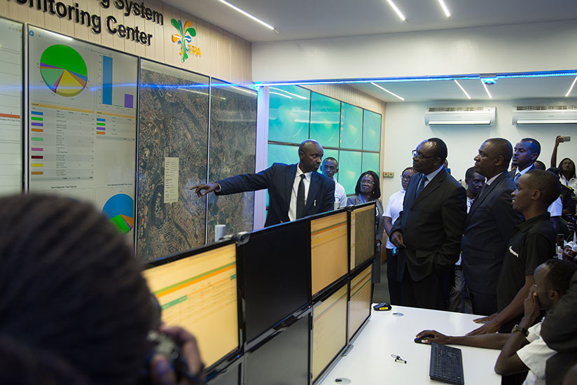 Robert Mugabe, the coordinator of the Cargo Tracking system, explains how the system works to the Trade, Industry and EAC Affairs minister Francois Kanimba (C), and other governmen....
