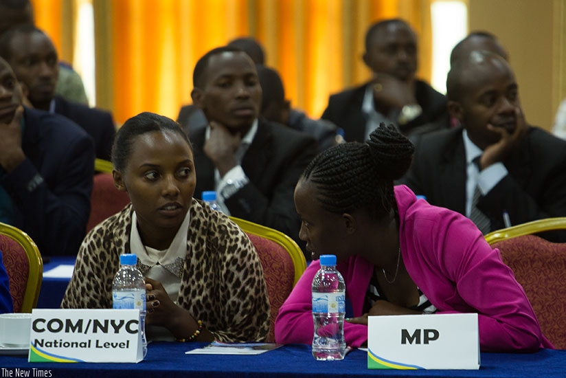 Justine Mukobwa, MP for the Youth at parliament (L) chats with Umutoni Chantal representative of high learning Institutions at the youth meeting. Timothy Kisambira