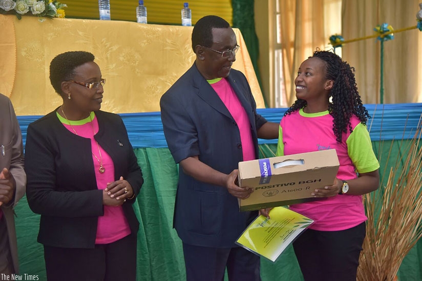 Makuza rewards one of the best performers as Amb. Jacqueline Mukangira, Board Member, Imbuto Foundation, looks on, in Rubavu District, yesterday.  Courtesy. 