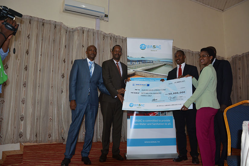Water and Sanitation Corporation Ltd (WASAC) chief executive James Sano (second-right), together with the chairperson of WASAC Board, Gisele Umuhumuza (right), hands over a cheque ....