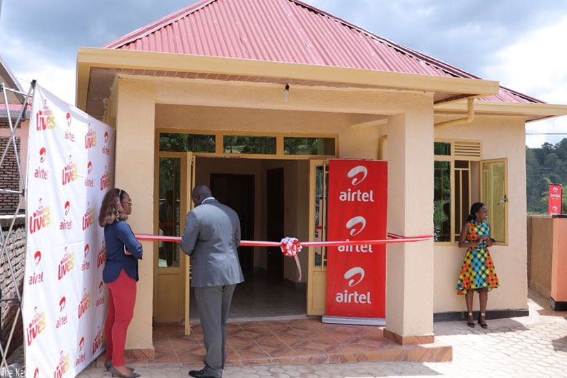 Kirungi (centre) cuts the tape as he unveils the house. (Courtesy photos)