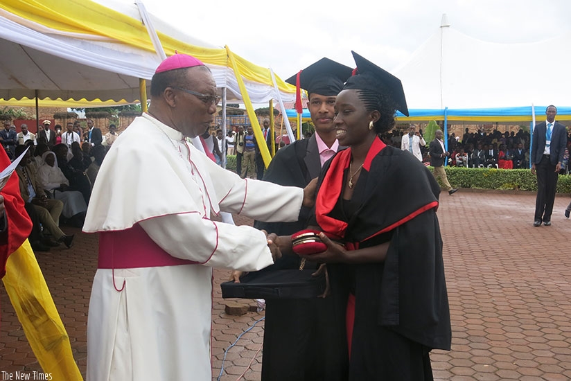 Monsignor Phillipe Rukamba congratulates a graduate. (Photo by Remy Niyingize)