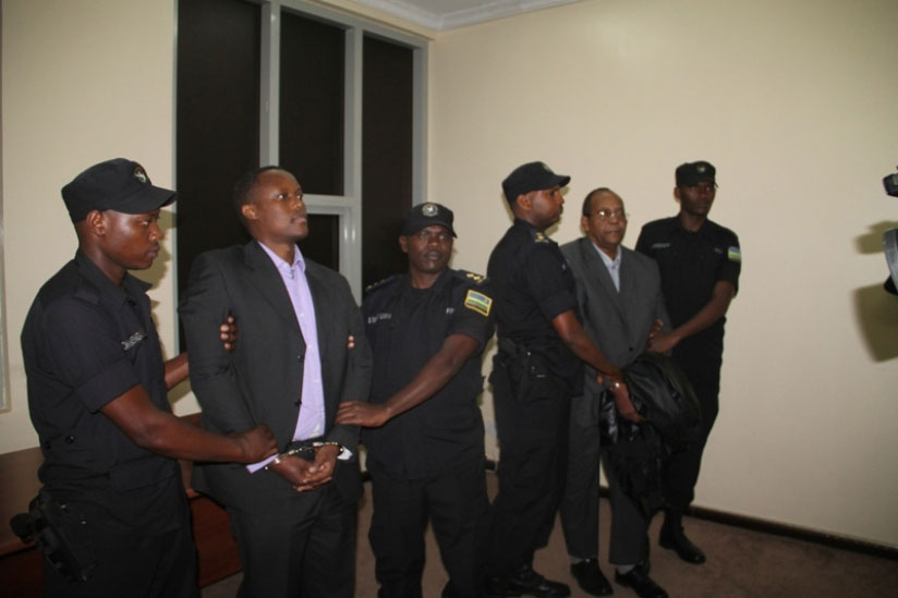 Jean-Claude Iyamuremye (L) and Jean-Baptiste Mugimba, are formally arrested by Rwanda National Police officers upon their extradition to face justice for their alleged role in the ....