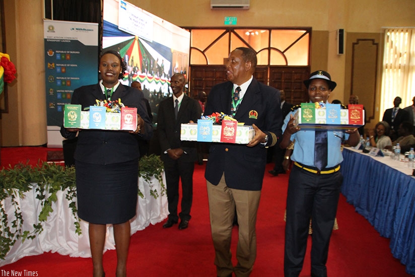Immigration officials from the EAC Partner States display the EA passport during the 16th Ordinary Summit of the Heads of State and Government last year. Courtesy. 