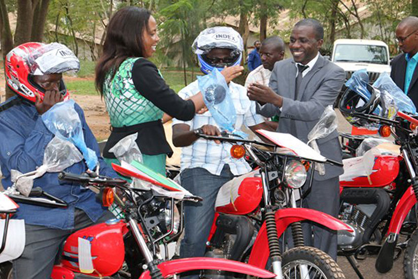 Urujeni (second left) hands over the motorcycles to some of the agronomists  last week in Kigali. The move seeks  to ease access to extension services by farmers. / Peterson Tumwebaze