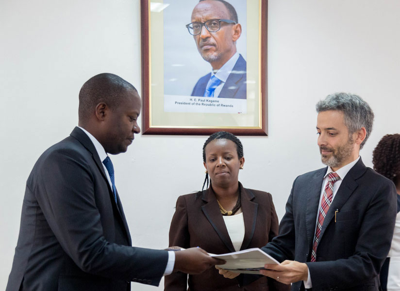 Cohen exchanges documents with Emmanuel Kamanzi, the EDCL chief, in Kigali. / Courtesy
