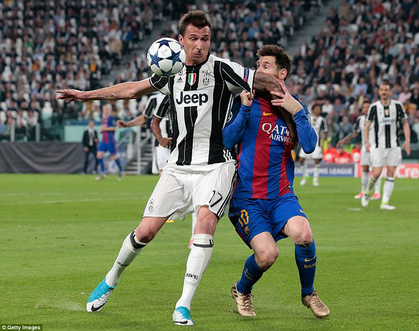 Mario Mandzukic (left) attempts to fend off Messi as the two players battle for possession. / Internet photo
