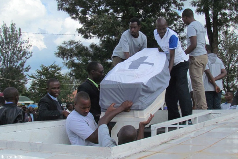 Remains of some of the 1994 Genocide against the Tutsi victims being lowered into a grave at Kiziguro memorial. (Photos by K. Rwamapera)