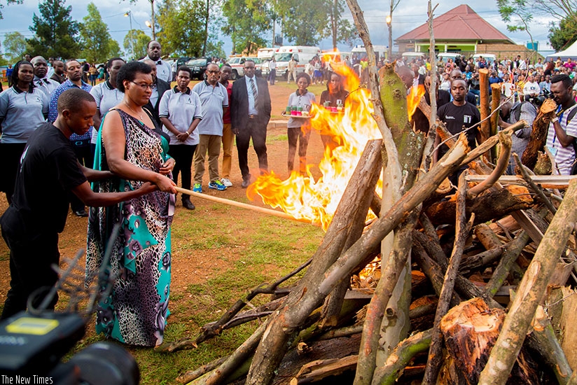 Speaker of Parliament Donatille Mukabalisa lights a fire at Nyanza memorial in Kicukiro, Tuesday night,  where mourners paid tribute to the thousands killed in the area following t....