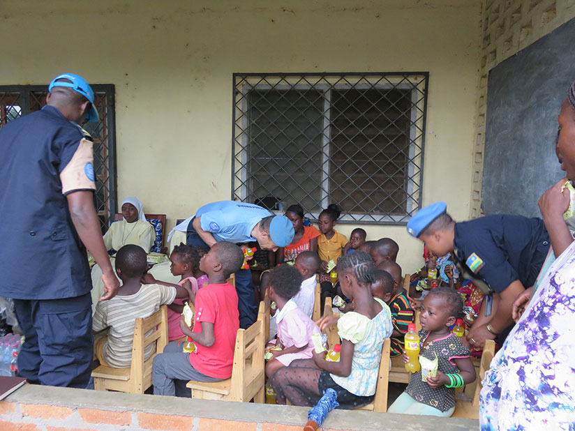 MINUSCA Police Commissioner and Rwandan peacekeepers feeding and interacting with the orphans. / Courtesy