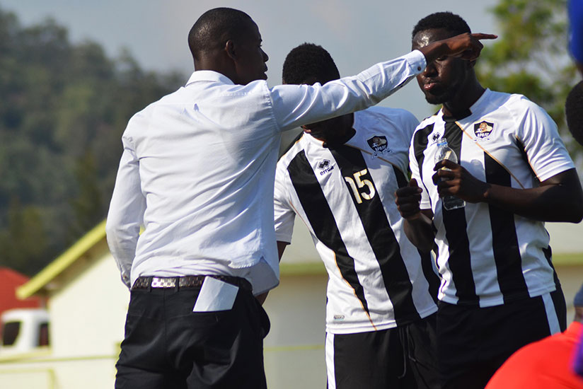 APR head coach Jimmy Mulisa talks to his players at the touchline during a recent league match. / File