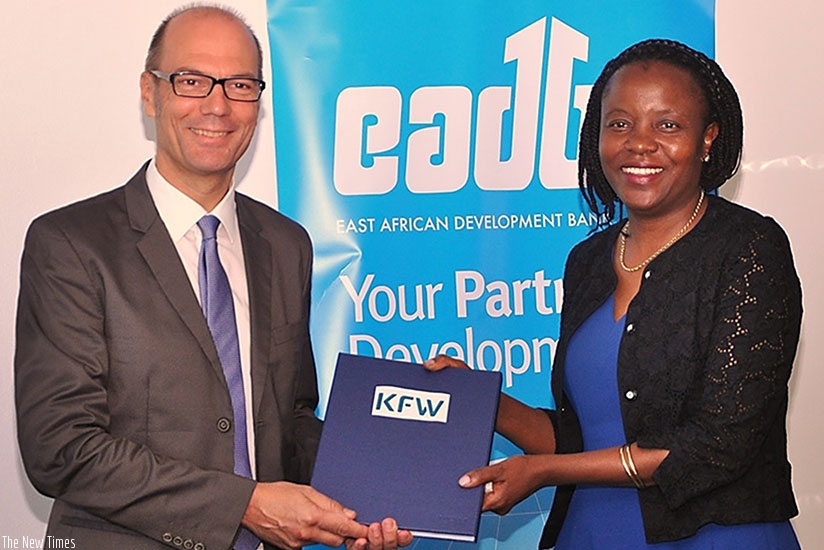Oliver Junger, the KfW Kampala office director, and EADBu2019s Yeda after signing the agreement. (Courtesy)