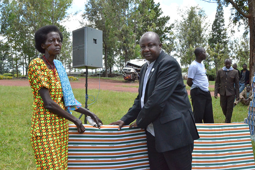 Mutagoma hands over a mattress to one of the Genocide survivors who were given mattresses in Kirehe. / Kelly Rwamapera