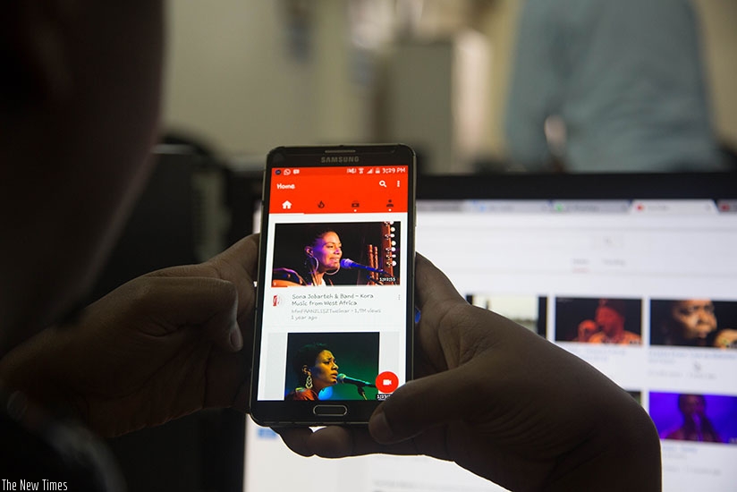A man watching a music video on Youtube on his mobile phone. African mobile operators need to  enter into deals with major broadcasters over streaming and download services. Courtesy