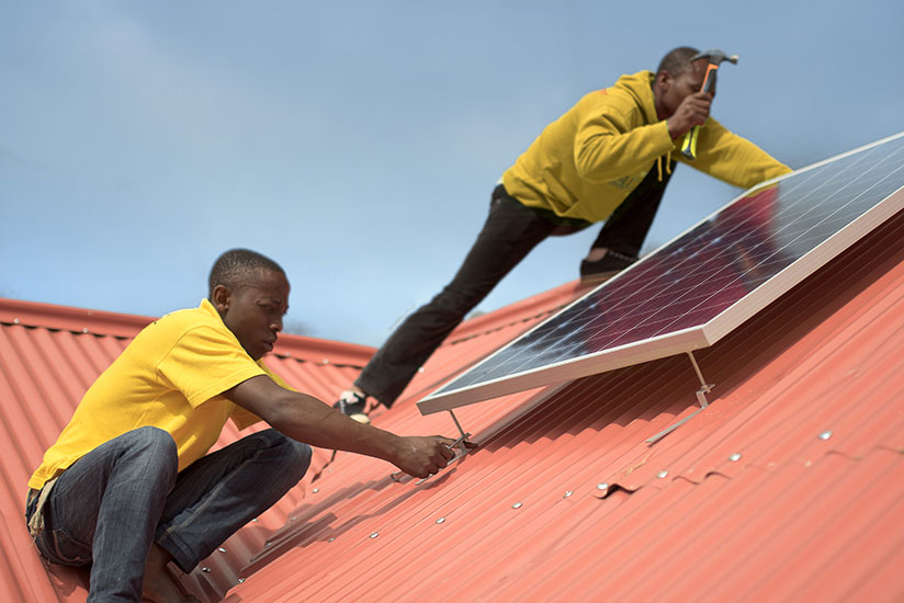 Technicians install a solar system. Government targets 22% off-grid connections by end of next year. / File