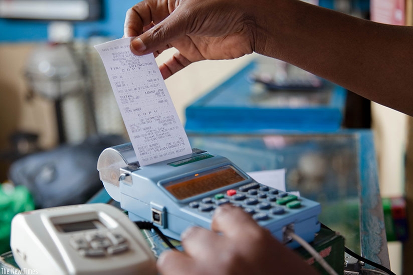 A trader pulls out a sales receipt from an electronic billing machine. (File)