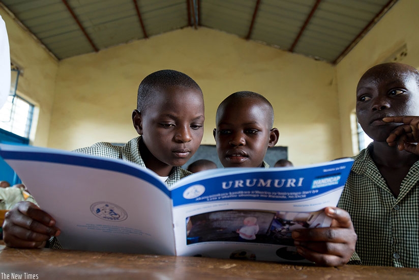 Pupils read a Kinyarwanda publication at GS Bumbogo in Gasabo District. (T.Kisambira)