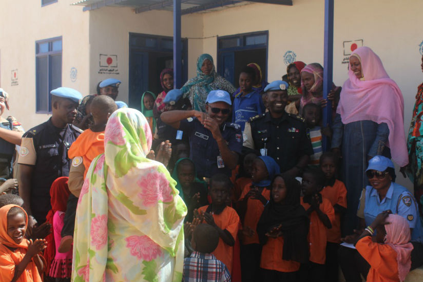 Rwanda police peacekeepers and UNAMID officials interacting with the women and children at the women centre block shortly after handing over the donation. / Courtesy