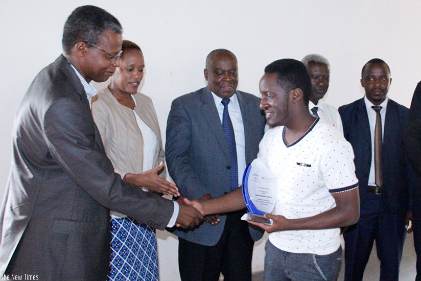 Gashirabakye receives an award from Nu-Vision school administration (Photos by F. Byaruhanga)