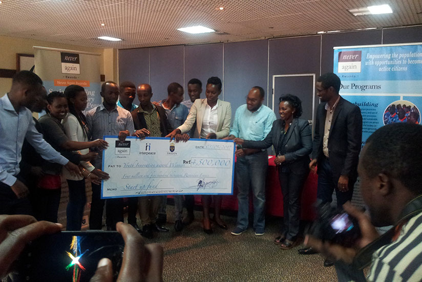 Heads of the nine youth associations that won cash prizes receive a dummy cheque on Wednesday in Kigali. / Eric Uwiringiyimana