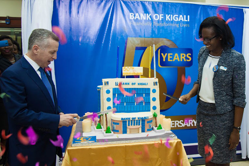 The CEO of Bank of Kigali Dr. Diane Karusisi (R) and the Chairman Marc Holtzman cut the giant cake designed in form of the BK Headquarters during the celebrations of it's 50th anniversary. 