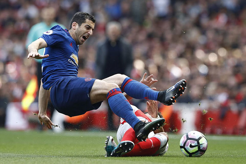 United's Henrikh Mkhitaryan is fouled by Arsenal's Alex Oxlade-Chamberlain during the first few minutes at the Emirates. Net photo