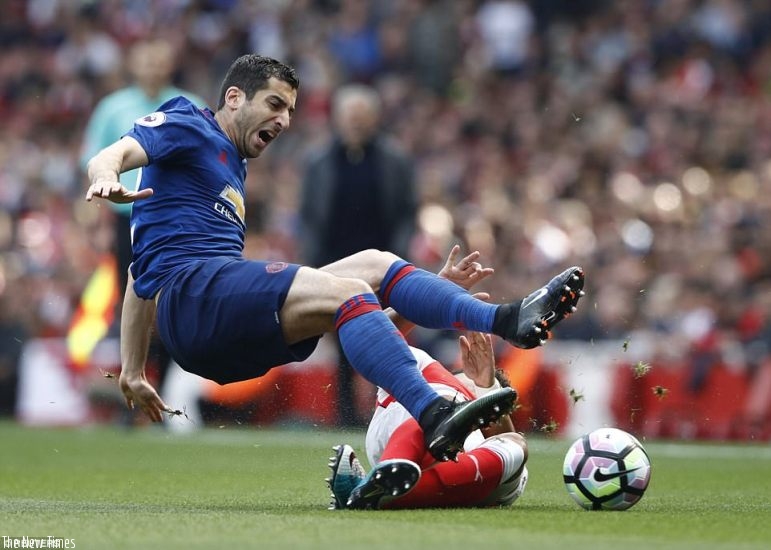 United's Henrikh Mkhitaryan is fouled by Arsenal's Alex Oxlade-Chamberlain during the first few minutes at the Emirates. (Net photo)