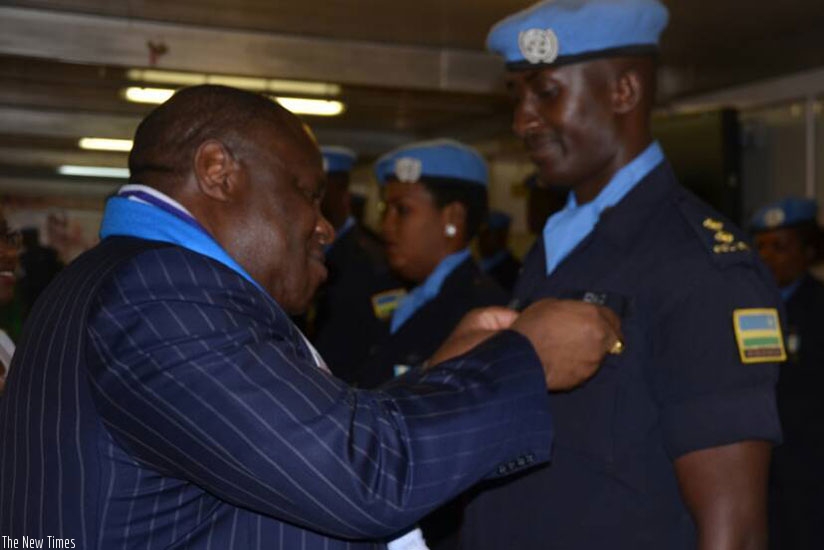 Joint Special Representative to UNAMID, Kingsley Mamabolo decorating one of the Rwandan Police peacekeepers.