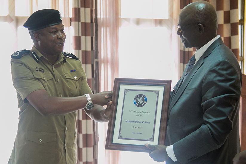 CP Kafeero Moses from Ugandan Police hands a gift to Minister Busingye on the behalf of his colleagues. (Photos by Faustin Niyigena)