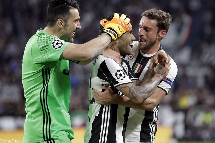 Alves celebrates in front of the crowd and is embraced by team-mates Buffon and Claudio Marchisio on Tuesday night