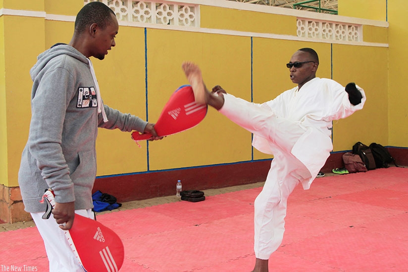 Jean Claude Niringiyimana during a practice session with his coach Allan Irene Bagire at Amahoro national stadium. S. Ngendahimana