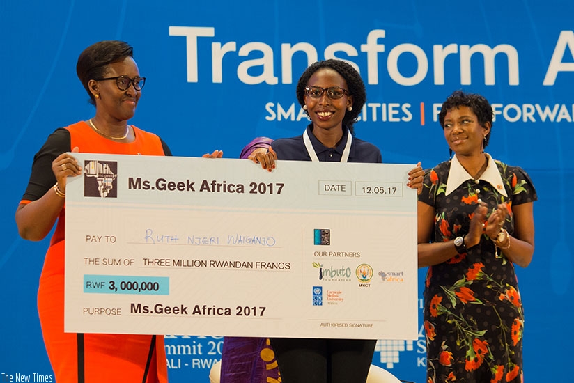 First Lady Jeannette Kagame (L) presents Miss Geek Africa 2017 Waiganjo with a dummy cheque yesterday. Timothy Kisambira.