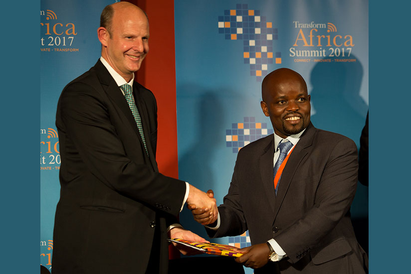 Rupert Pearce, chief executive of Inmarsat, a global mobile satellite communications firm, exchanges documents with Youth and ICT minister Jean-Philbert Nsengimana in Kigali last week. During the Transform Africa Summit, a UAE-based firm also committed to invest $50 million (about Rwf41 billion) in the recently launched Rwanda Smart City Master Plan. / Timothy Kisambira