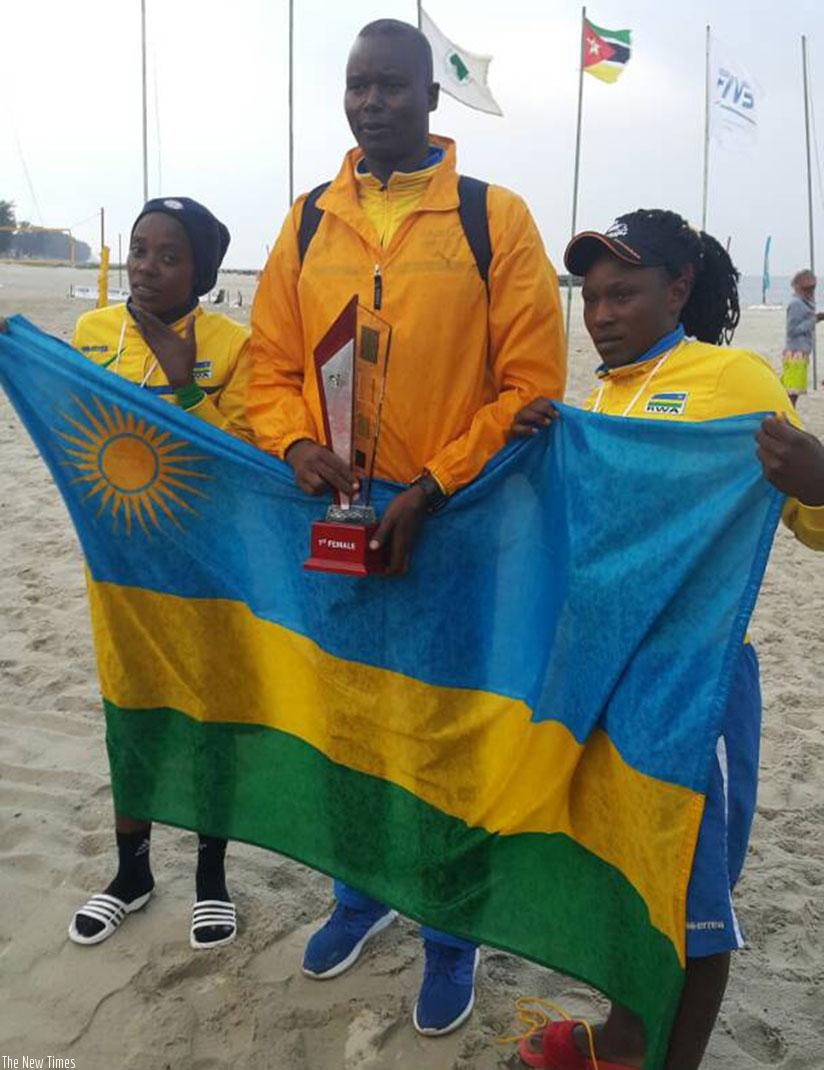 Coach Paul Bitok (in the middle) holds the title as he poses for the photo with the pair of Nzayisenga and Mutatsimpundu on Sunday in Maputo. (Courtesy)