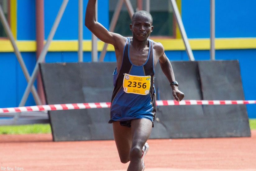Jean Baptiste Ruvubi waves to the cheering crowd as he crosses the finish line at the 2015 Kigali Peace Marathon to finish second in the men's full marathon. (File)