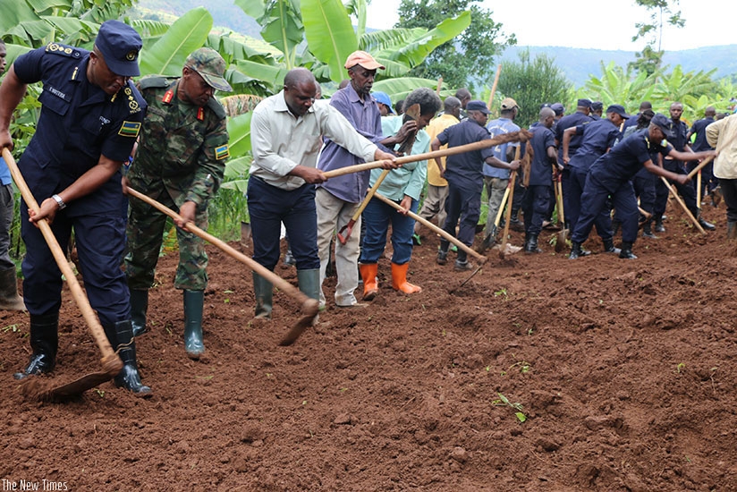 Senior government and security officials, and residents take part in Umuganda to construct a road in Rugarama Village in Giti Sector. (File)