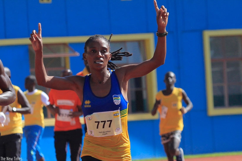 Salome Nyirarukundo raises her arms in the air in celebration after  winning the gold medal in women half marathon at Amahoro National Stadium on  Sunday. (Sam Ngendahimana)