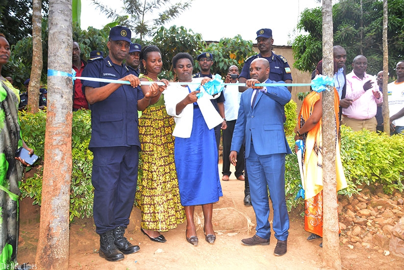 Minister Venantie Tugireyezu flanked by the Mayor of City of Kigali Pascal Nyamulinda and CP Daniel Nyamwasa cutting a ribbon as a symbol to handover the solar systems in Nyarugenge. 
