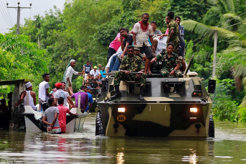 Sri Lankan soldiers evacuate flood victims while also carrying relief material, at a flooded area in Wehangalla village in Kalutara district, yesterday. rnNet photo.