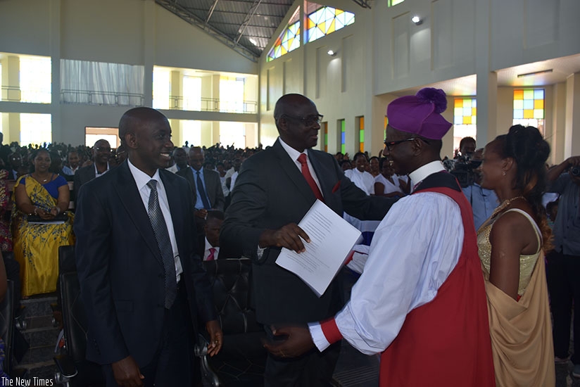 Justice minister Johnston Busingye (C) congratulates Bishop Gahima upon his consecration as Kaboneka (L) looks on yesterday. Jean d'Amour Mbonyinshuti.