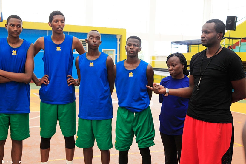 U-16 boys team assistant coach Aime Kharim Nkusi (R) talks to the players following their final training session yesterday at Amahoro Indoor Stadium in Remera. (Sam Ngendahimana)