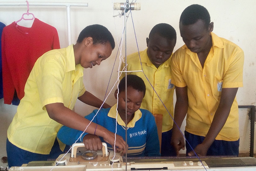 Kelly Umwiza (left) shows her peers how to use a sewing machine. (Photos by Remy Niyingize)