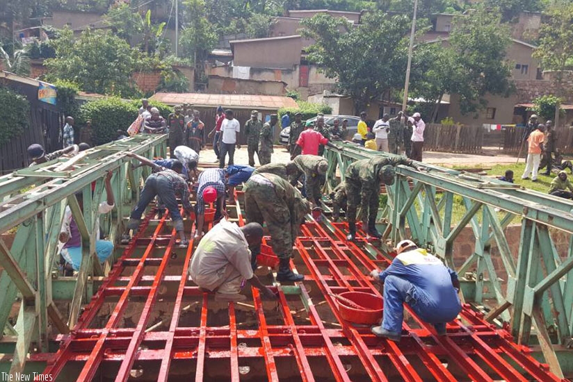 Army officers are joined by residents to construct a bridge. (Courtesy)