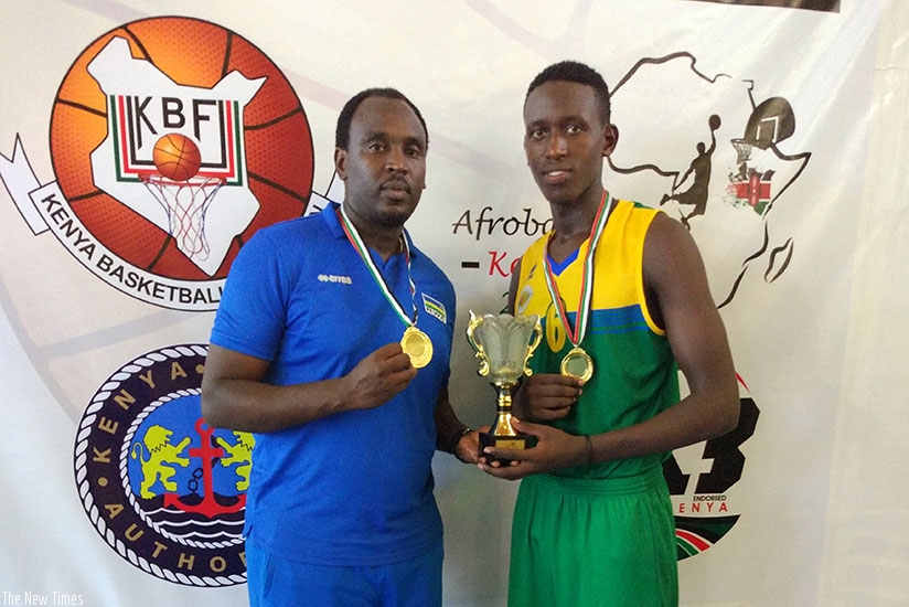 Youngster Thierry Nkundwa poses for a  photo with head coach Moise Mutokambali after guiding Rwanda to the Zone V U16 title on Monday. rnGeoffrey Asiimwe.