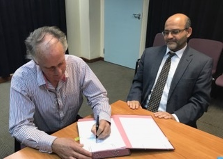 Inyenyeri CEO, EricReynolds signs as World Bank Group's El-Gammal looks on (Courtesy photos)