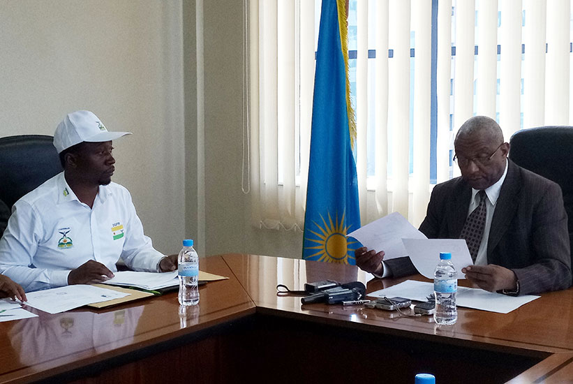 NEC chairperson Kalisa Mbanda (R) scrutinises documents of Habineza. / Sam Ngendahimana