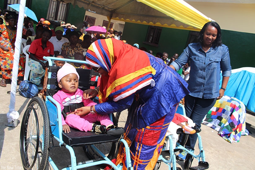 Senate vice-president Fatou Harerimana takes care of a disabled child during the tour of the orphanages with Minister Nyirasafari (R) yesterday. Frederic Byumvuhore.