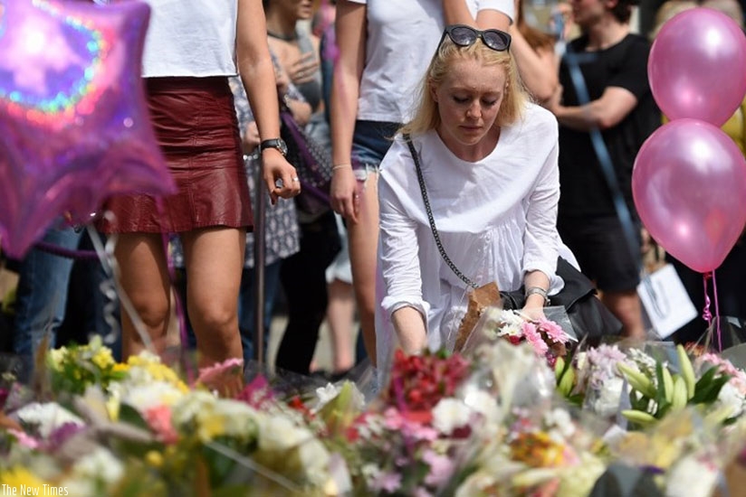 A woman places flowers in St Annu2019s Square in Manchester, northwest England. (Net photo)