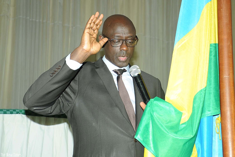Minister Busingye takes oath before delivering his speech. (Francis Byaruhanga)
